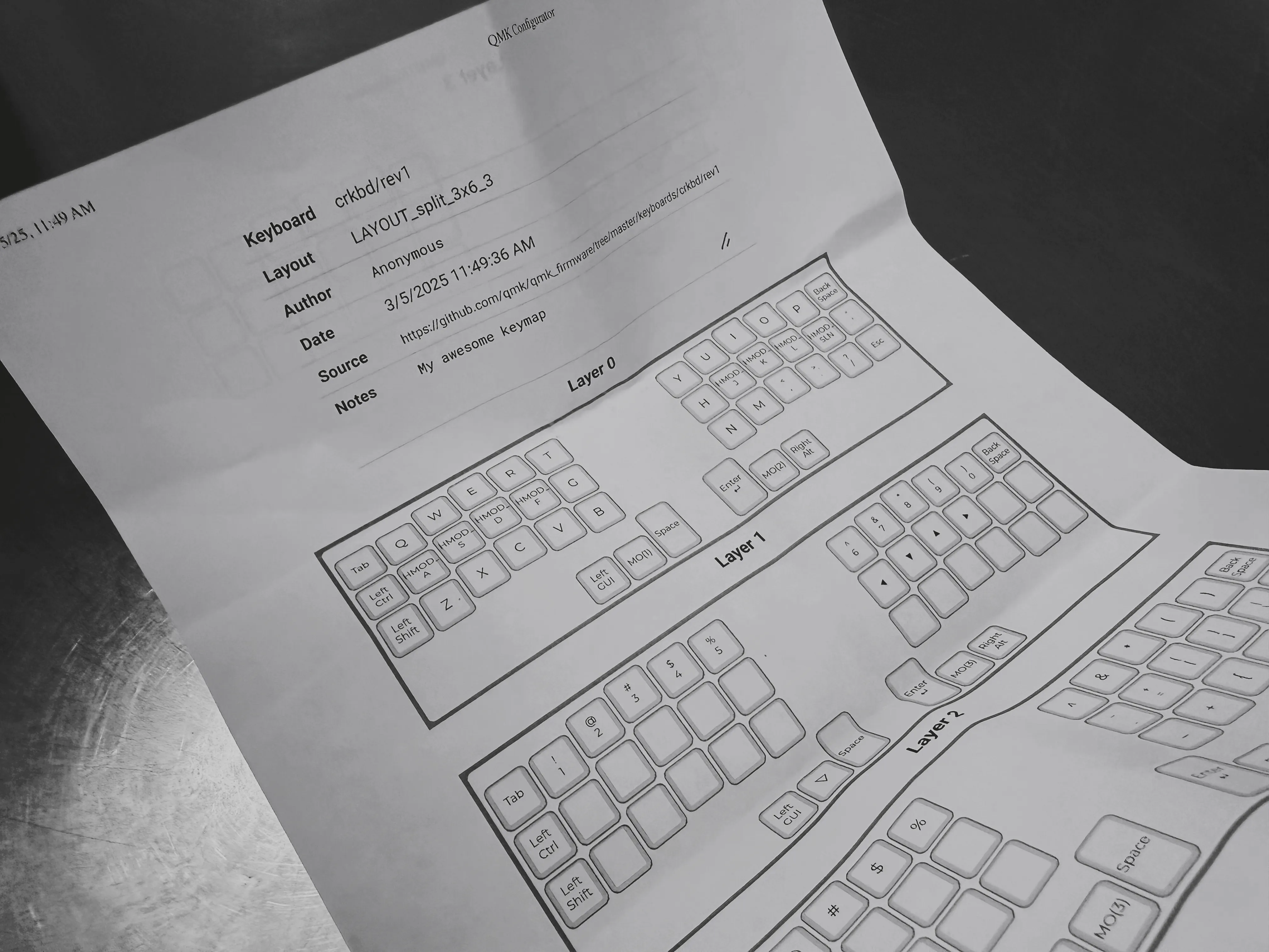 A print out of my keyboard layout from QMK Configurator. It shows some meta information about the layout and the various layers I've configured.